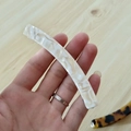 Dettaglio ravvicinato di un fermaglio per capelli a banana in acetato marmorizzato a mano - Floreale Crema