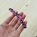 Detail der eleganten rosa Marmor-Acetat-Bananenspange zur Darstellung der Textur - Rot Floral