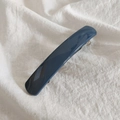 Macro shot of a glossy dark blue acrylic hair clip on white textured linen fabric - Navy Blue
