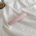 Detail of elegant rectangular light pink hair clip with a glossy glaze finish on fabric - Pink