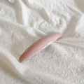 Detail of pink curved hair clip on white textured linen background showing resin finish - Pink