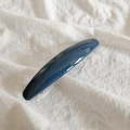 Detailed view of the dark blue glossy acrylic hair clip on white fabric background - Navy Blue