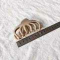 Makroansicht der 10cm minimalistischen beigen Haarklammer mit Lineal zur Größenmessung - Glänzendes Khaki