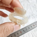 Dettaglio di una piccola clip per capelli leopardata con righello che misura 4 cm - Beige Floreale