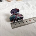 Detail view of a 4cm small marbled acetate hair claw clip with colorful purple and cyan swirls - Dark Purple Floral
