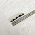 Detail view of a 6.5cm marble pattern acetate hair clip with a measuring ruler - Black Series