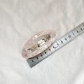 Macro view of pink marble oval hair clip showing 6.5cm length on a stainless steel ruler - Pink Floral