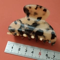 Detailed view of an 8cm amber acetate hair claw clip with scale measurement on red background - Pastel Colors