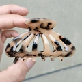 Detalle de pinza para el pelo de acetato carey sostenida en la mano para ver tamaño - Color Claro