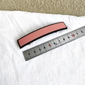 Detalle de pinza para cabello rectangular rosa de 8,8 cm sobre una regla de medición - Rosa Claro