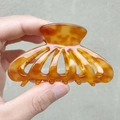 Detalle de pinza para el cabello de acetato ámbar con diseño hueco y textura marmoleada - Marrón Caramelo