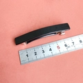 Detalle de una pinza para el pelo negra brillante de 8 cm con regla de medida - Negro