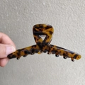 Primer plano de pinza para el pelo carey grande con patrón de leopardo ámbar pulido - Color Oscuro