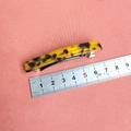 Primer plano de pasador de pelo de 8cm con carey y regla de medida sobre fondo naranja - Carey Amarillo Oscuro