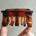 Detailed close-up of large tortoiseshell amber hair claw clip with multi-tooth design - Caramel color