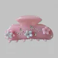 Dettaglio della pinza per capelli rosa con motivi floreali e strass scintillanti - Rosa Porpora