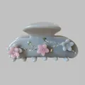 Dettaglio della molletta floreale con fiori rosa e strass scintillanti a forma di foglia - Grigio