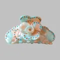 Detail view of flower hair claw clip with mint green acetate and sparkling rhinestones - Green Tones