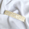 Detail of a large French acetate hair clip with cream marble texture on white silk fabric - 7# Off-White System