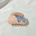 Detailaufnahme der halbkreisförmigen rosa Marmor-Haarklammer mit glänzenden Schmetterlingskristallen - Rosa