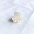 Close-up of a mini cream white acetate hair claw clip on white textured fabric background - Mermaid White