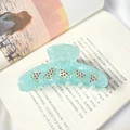 Dettaglio molletta per capelli blu menta con angurie di strass su un libro aperto a casa - Verde smeraldo