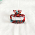 Detail of square acetate hair claw with red blue marble texture and metal spring - Transparent Red Series