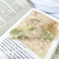 Detailed close-up of a large marbled acetate hair claw clip on an artistic book background - Pink and Green Floral-11cm