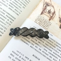 Barrette à cheveux vintage en acétate gris foncé marbré sur un livre rétro élégant - Marbre Noir Gris