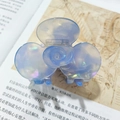 Hellblaue irisierende Blumen-Haarklammer mit Perlmutteffekt auf Vintage-Buch-Hintergrund - Himmelblau