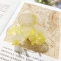 Elegant yellow marble texture flower hair claw clip displayed on a vintage book page - Yellow