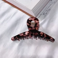 Large acetate hair claw clip featuring a dark leopard tortoiseshell pattern on white fabric - Black & Pink