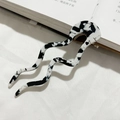 Macro-detail van de U-vormige acetaat haarspeld met chique zwart-witte koeienprint textuur - Zwart en Wit Gespikkeld