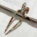 Forcina a U in acetato verde marmorizzato su un libro aperto per uno stile vintage - Marrone Floreale