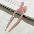 Dettaglio della forcina a U in acetato rosa chiaro effetto marmo su superficie in tessuto - Rosa Floreale