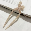 Dettaglio della forcina a U in acetato beige marmorizzato con design a orecchie di coniglio - Floreale Albicocca