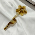 Détail de la pince à cheveux fleur en écaille ambrée avec cristal sur tissu blanc doux - Kaki