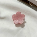 Roze mini bloem haarclip met glitterafwerking op een minimalistische witte ondergrond - Roze