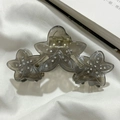 Detailed view of smoky grey acetate flower hair claw with sparkling rhinestone centers - Gray