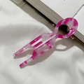 Makro-Detail der U-förmigen Haarnadel aus marmoriertem Acetat auf weißem Stoff - Rosa