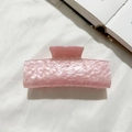 Dettaglio di un mollettone in acrilico rosa marmorizzato su un tessuto bianco morbido - Rosa