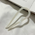 Detail of pearlescent white acetate U-shaped hair pin for elegant bun styling - Mermaid White