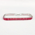 Vista macro di un braccialetto argentato con zirconi rossi rettangolari e montatura a griffe - 19cm / Stile Zirconia Rossa Placcato Platino