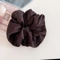 Detail view of large dark brown fabric scrunchie with denim texture on a vintage book - Brown