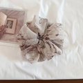 Detailansicht eines großen Haargummis mit floralen Tuschemustern auf cremefarbenem Stoff - Beige Kaffee Blumig