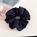 Macro detail of dark denim fabric hair scrunchie with white brand label and twill texture - Dark Blue