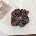 Détail du chouchou en tissu marron à pois posé sur un arrière-plan en tissu blanc - Café (Standard)