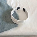 Gros plan d'un serre-tête en satin blanc plissé avec des couches texturées élégantes - Blanc