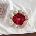 Detailed close-up of a red and white ruffled knit scrunchie with soft yarn texture - Red and Beige Patchwork