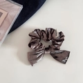 Detalle de coletero de terciopelo topo con etiqueta FMdrea sobre fondo blanco - café